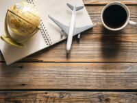 earth-globe-airplane-model-coffee-cup-notepad-wooden-background-top-view_optimized_1024x682.jpg