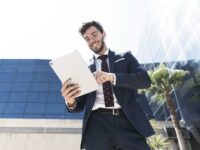 low-angle-smiley-man-with-his-tablet_optimized-scaled.jpg